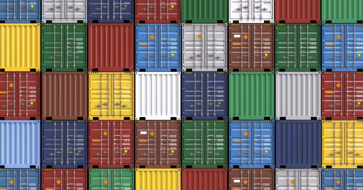 A uniform stack of colorful square shipping containers, including dark blue, yellow, dark red, and green, fills the frame.