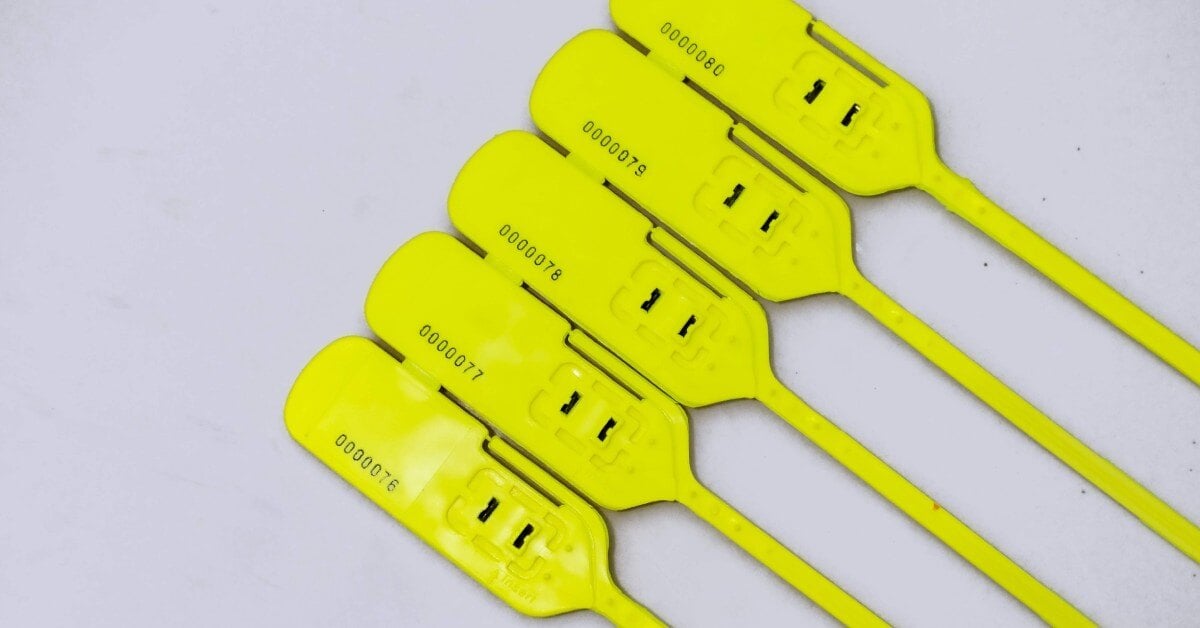 Four yellow plastic security seals lying flat on a white background. The seal is broken and previously used.