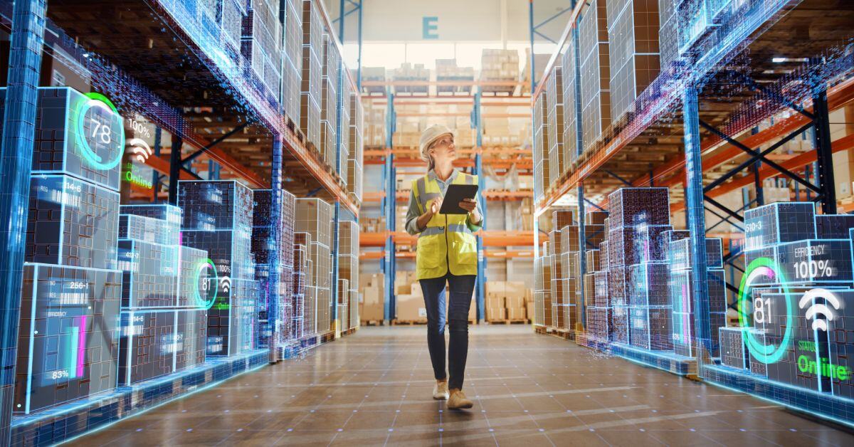 A woman wearing a reflective vest and hard hat holds a tablet and looks at warehouse shelves overlaid with data statistics.
